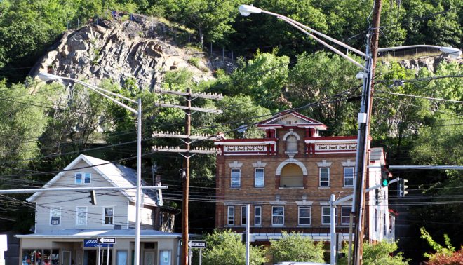 The looming, exposed rock of Nordkopf Mountain in Suffern, New York. Old telegraph poles still display their porcelain insulators.